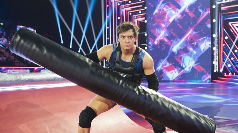 Apollo holding a padded pole in the Gauntlet of BBC One's Gladiators